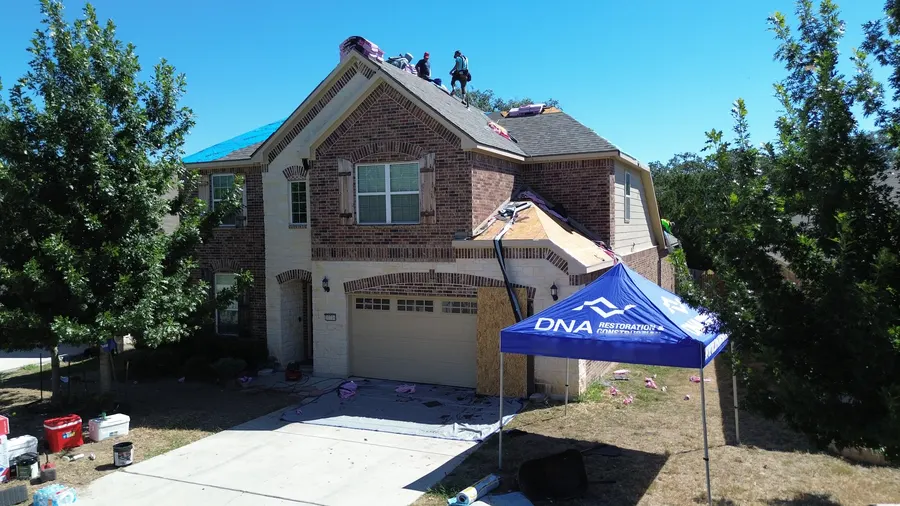 DNA crew on a two-story roof replacement by DNA Restoration & Construction