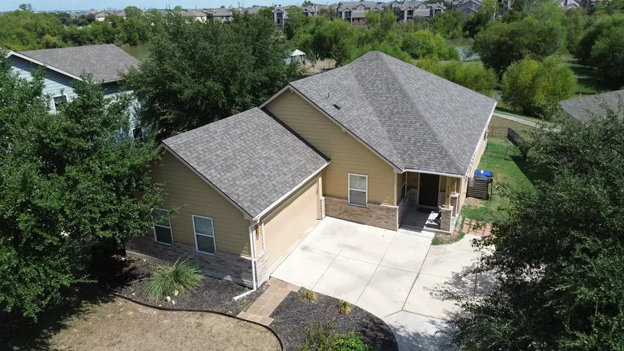 Drone photo of a finished DNA roof replacement in San Antonio with a clean driveway, yard and flower beds