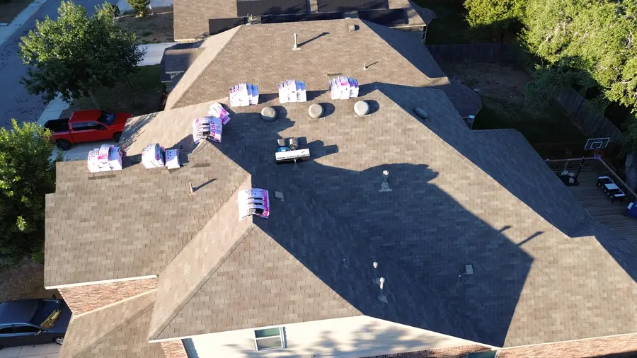 Drone photo of shingle bundles delivered directly onto a San Antonio roof before a DNA roof replacement
